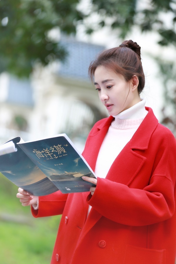 素颜女神王丽坤身穿红色外套和白色毛衣研读剧